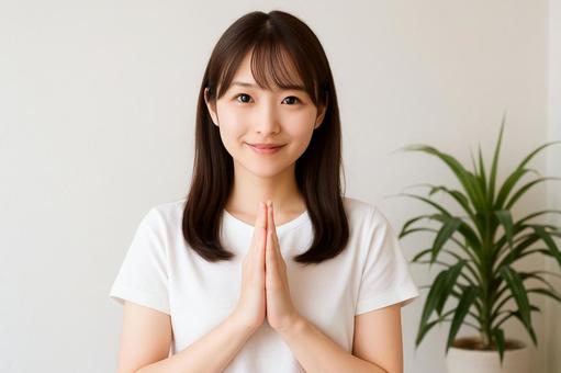 手を合わせてお願いする女性 手を合わせてお願いする女性の写真
