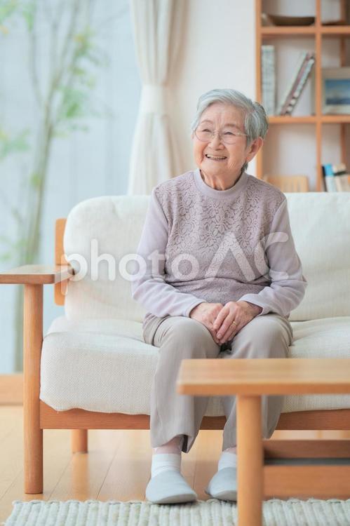 ソファに座り微笑むおばあちゃん 女性,微笑む,ソファの写真素材