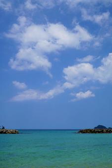 沖合のテトラポッドと水平線に広がる青空の写真