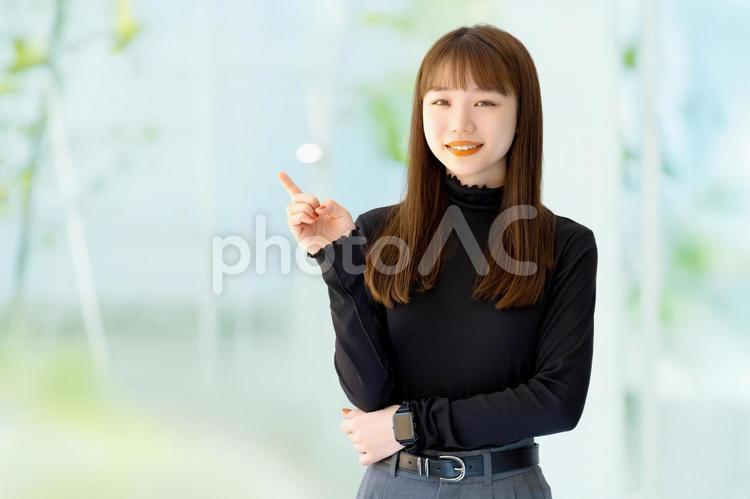 人差し指を立てて案内するビジネスウーマン 女性,ビジネス,笑顔の写真素材
