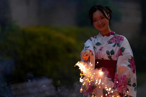 浴衣姿の女性が手持ち花火を楽しむ 女性,浴衣,花火の写真素材
