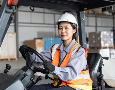 フォークリフトを運転する女性作業員の写真