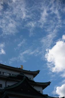 青空に輝く名古屋城の金鯱の写真
