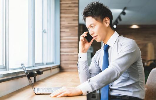 スマホで通話をする笑顔の男性ビジネスマン スマホで通話をする笑顔の男性ビジネスマン 男性,スマホ,スマートフォンの写真素材
