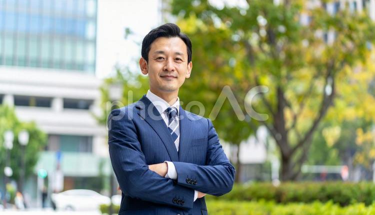腕組みするスーツ姿のアジア人ビジネスマン 腕組,ガッツ,笑顔の写真素材