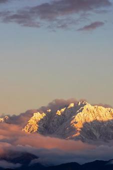 夕日に染まる雪山の山頂_縦 夕日に染まる雪山の山頂_縦 立山連峰,雪山,冬の写真素材
