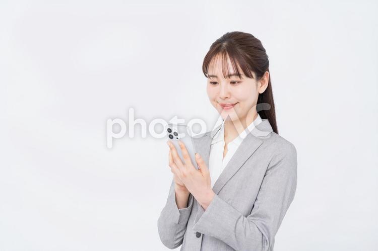 スマホを使うビジネスパーソン。 スマホ,スマートフォン,女性の写真素材