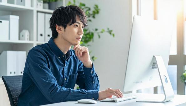 PC作業をするビジネスマン PC作業をするビジネスマンの写真