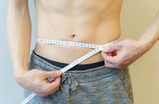 腹部をメジャーで測る若い日本人男性の手元 お腹,ダイエット,男性の写真素材