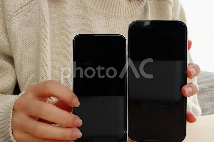 スマホ2台を持つ女性の手 スマホ2台を持つ女性の手 スマホ,iphone,比較の写真素材