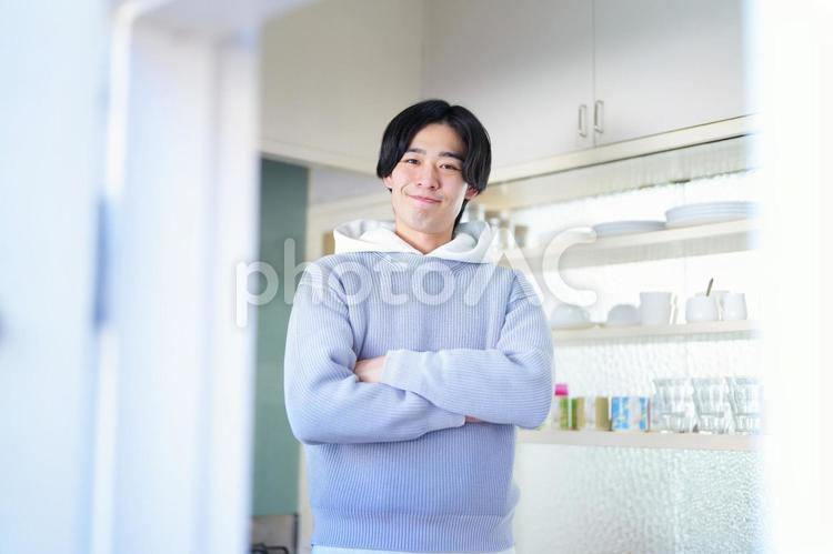 キッチンで腕組みをして立っている男性 引っ越し,一人暮らし,男性の写真素材