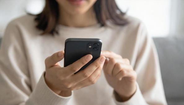 スマホを操作する女性 スマホを操作する女性の写真
