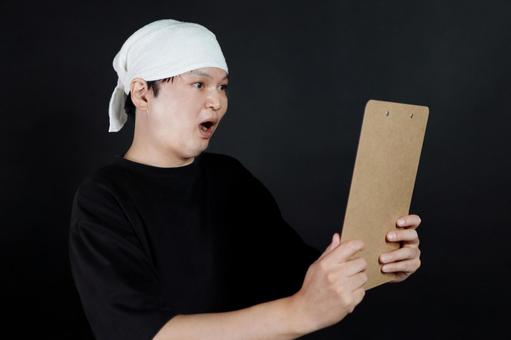 驚く男性とクリップボード 驚く男性とクリップボードの写真