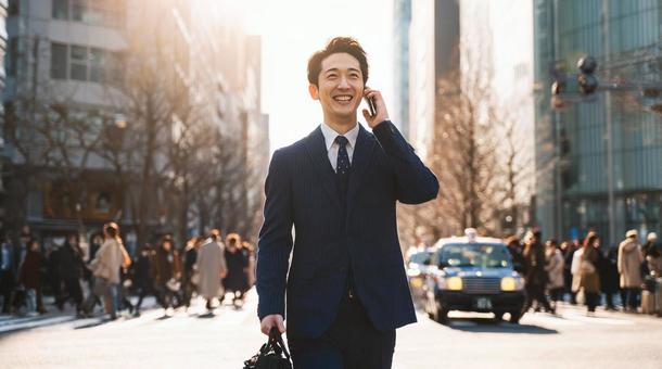 街中を電話しながら歩くビジネスマン 街中を電話しながら歩くビジネスマンの写真