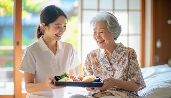 高齢女性と女性介護士の穏やかな食事風景 高齢女性と女性介護士の穏やかな食事風景の写真