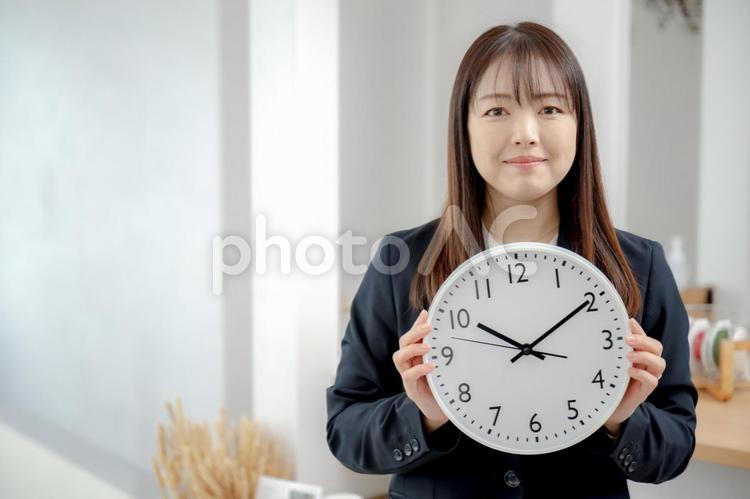 時計とビジネスウーマン 女性,ビジネスウーマン,スーツの写真素材