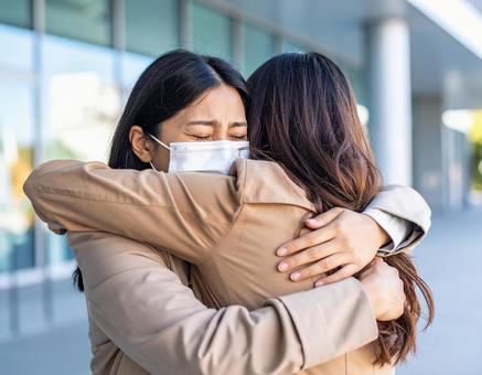 感動の再会:マスク越しに抱き合う女性たち 感動の再会:マスク越しに抱き合う女性たちの写真