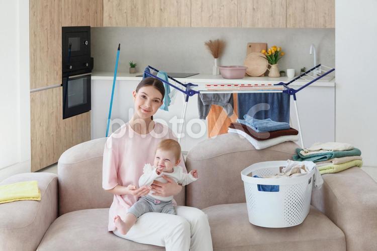 赤ちゃんを抱っこしてソファーに座っている女性 親子,女性,人物の写真素材