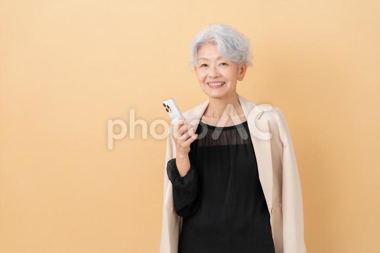 ベージュバックのシニアのビジネスウーマン ビジネス,女性,シニアの写真素材