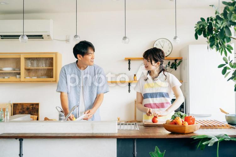 料理とお皿洗いをする男女（夫婦） 家事分担,料理,キッチンの写真素材