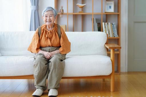 リビングで笑っているソファのおばあちゃん 女性,笑顔,座るの写真素材