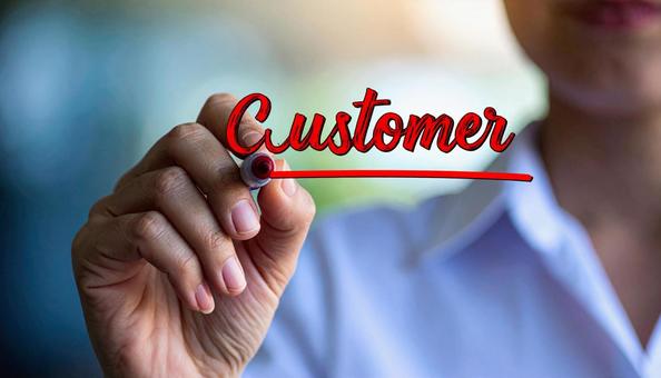 文字CUSTOMERと赤ペンで書く女性の写真