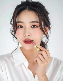 リップを塗る若い女性の美容ポートレートの写真