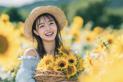 夏のひまわり畑で花を持つ笑顔の若い女性 夏のひまわり畑で花を持つ笑顔の若い女性の写真