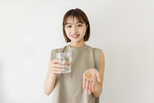 サプリメントを飲む女性 女性,人物,サプリメントの写真素材