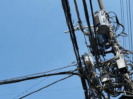 青空と複雑に交差する電柱・電線 電柱,電線,柱上変圧器の写真素材