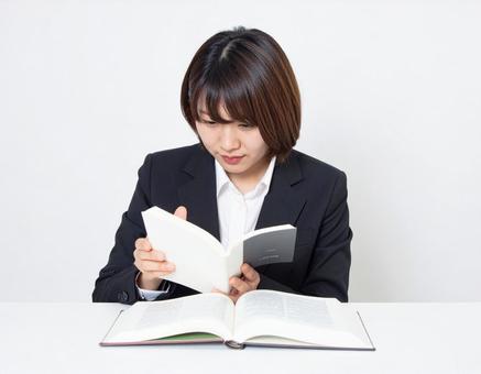 書類を確認するビジネスウーマン 書類を確認するビジネスウーマンの写真