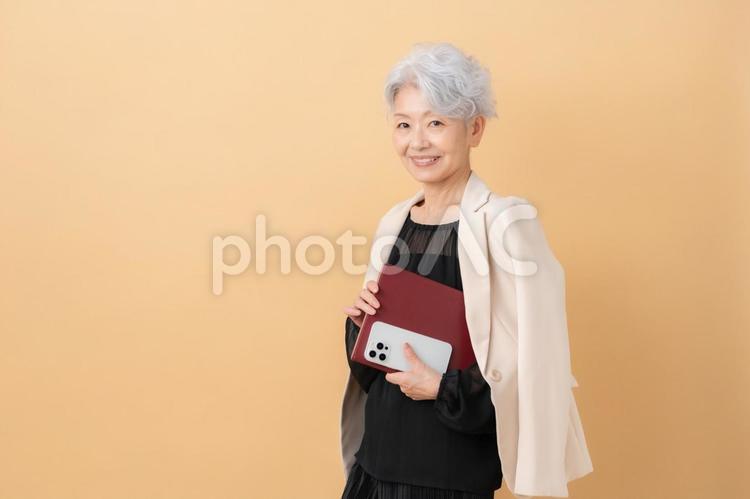 ベージュバックのシニアのビジネスウーマン ビジネス,女性,シニアの写真素材