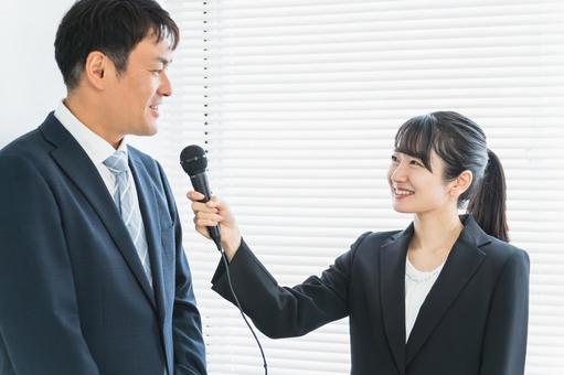 インタビューを受ける男性とマスコミの女性 取材,報道陣,インタビューの写真素材