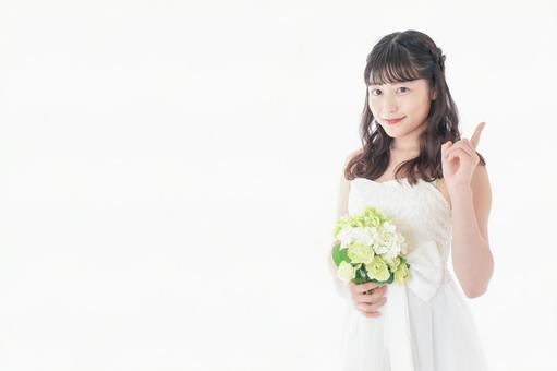 ブーケを持ち指差す花嫁の女性 ブーケを持ち指差す花嫁の女性 注意点,ハンド,ウェディングドレスの写真素材