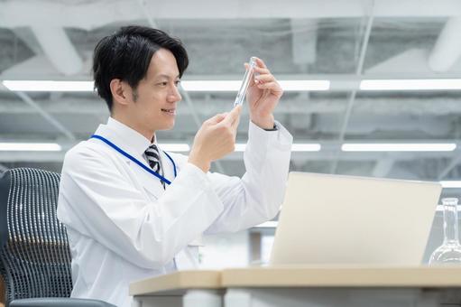実験をする白衣の若い男性研究者 実験をする白衣の若い男性研究者 研究,実験,サイエンスの写真素材