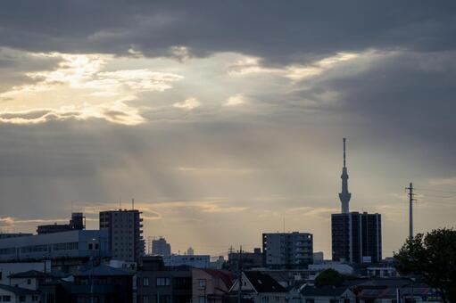 放射状に光が差し込む夕暮れの街並み 雲,光,筋の写真素材