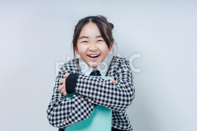 タブレットを抱えた笑顔が可愛い女の子 女性,小学生,少女の写真素材