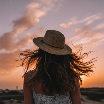 夕日を背に風になびく髪の女性 夕日を背に風になびく髪の女性の写真
