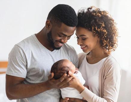 愛おしそうに赤ちゃんを見つめる夫婦 愛おしそうに赤ちゃんを見つめる夫婦の写真
