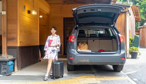 温泉旅館の玄関で送迎バスを待つ女性 温泉旅館の玄関で送迎バスを待つ女性の写真