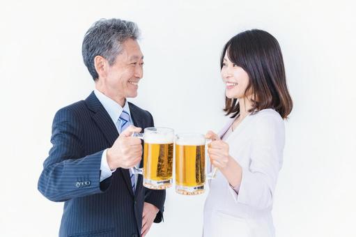 上司と乾杯をする女性社員 生中,飲む,忘年会の写真素材
