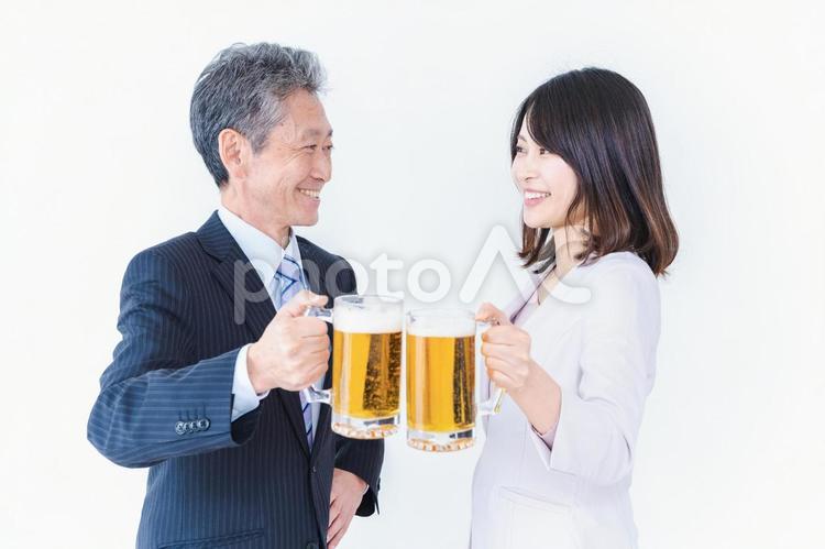 上司と乾杯をする女性社員 生中,飲む,忘年会の写真素材