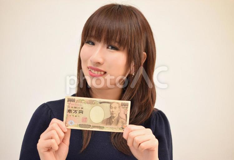 一万円を見せる女性：副収入イメージ 女性,お金,副業の写真素材