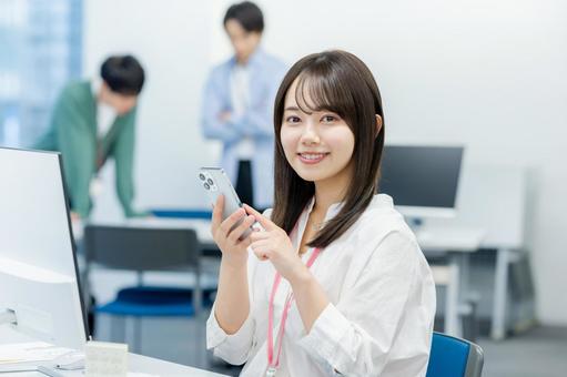 オフィスでスマホを持つビジネスウーマン スマホ,笑顔,ビジネスウーマンの写真素材