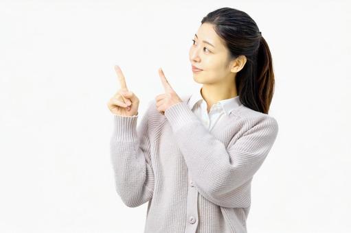指さしポーズで案内する若い女性 指さしポーズで案内する若い女性 指差し,女性,お知らせの写真素材