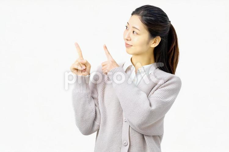 指さしポーズで案内する若い女性 指差し,女性,お知らせの写真素材