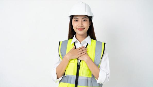 胸に手を当てる作業着の日本人女性 胸に手を当てる作業着の日本人女性の写真