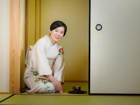 33:お茶をお出しする着物の女性 33:お茶をお出しする着物の女性 着物,おもてなし,お茶だしの写真素材