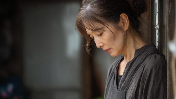 うつむく年配の女性 うつむく年配の女性の写真