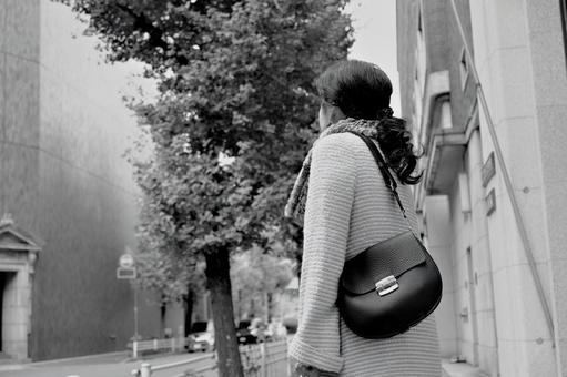 バッグを持つ女性の後ろ姿 白黒 バッグを持つ女性の後ろ姿 白黒の写真